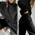 Detail view of black oversized hoodie and cargo sweatpants set for women's streetwear. - Black