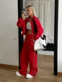 Full-length view of a woman in a red two-piece tracksuit with white piping detail - S / Top And Bottom / Red