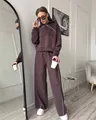 Full view of brown two-piece women's tracksuit set with white piping in chic room - S / Top And Bottom / Coffee