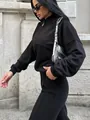 Λεπτομέρεια μαύρης γυναικείας αθλητικής φόρμας δύο τεμαχίων με φερμουάρ σε στυλ δρόμου - S / Τοπ Και Παντελόνι / Μαύρο