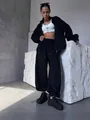 Dettaglio del set lounge nero due pezzi da donna con crop top bianco e scarpe con zeppa - Taglia S / Top E Pantaloni / Nero