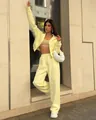 Vista completa di un set da casa giallo a 2 pezzi con felpa con cappuccio e pantaloni larghi - Taglia S / Top E Pantaloni / Giallo
