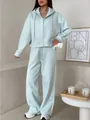 Model wearing a light blue two-piece hooded zip-up sports set with wide-leg pants - S / Top And Bottom / Cyan