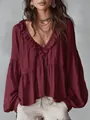 Dettaglio di una blusa bordeaux con scollo a V, bordi con volant e maniche a sbuffo - Rosso