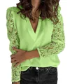 Detailed view of lime green V-neck blouse with intricate floral lace on long sleeves. - S / Tops / Green