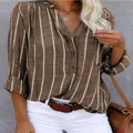 Detailed view of women's brown vertical striped blouse with henley neck design - S / Tops / Khaki