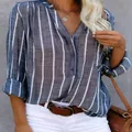 Detail view of a blue and white vertical striped long sleeve shirt with V-neckline - S / Tops / Blue