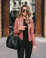 Streetstyle-Ansicht einer Frau in einer rosa Kunstlederjacke und schwarzer Hose - S / Oberteile / Khaki
