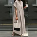 Abito lungo ampio in cotone e lino beige, mostrato in un ambiente esterno casual - Taglia S / Grigio chiaro