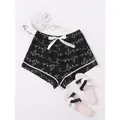 Stylish women's summer pajama shorts with black script print and elegant white bow. - S / Bottoms / Black With Letter Print