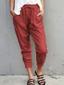 Women's red cotton linen drawstring casual pants showing slim fit and cropped leg detail. - Burgundy