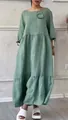 Detailed view of sage green casual linen dress featuring a stylish pleated flower accent - Green