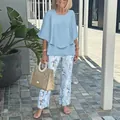 Full body view of women wearing casual light blue top and floral pants with straw bag - XS / Top And Bottom / Light Blue Floral (06)