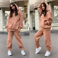Deux angles d'un ensemble de survêtement caramel pour femme avec sweat à capuche - Chameau
