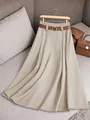 Détail rapproché d'une élégante jupe plissée évasée kaki avec une ceinture marron stylée - Abricot
