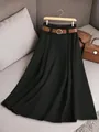 Vue détaillée d'une élégante jupe plissée noire avec une ceinture marron décorative - Noir