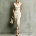 Elegant sleeveless beige midi dress with asymmetric draping and waist detail on model - S / Milky White
