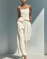 Elegant cream two-piece set featuring a diagonal button camisole and matching wide-leg trousers - S / Top And Bottom / Ivory
