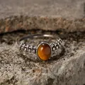 Detailed macro shot of a vintage S925 sterling silver ring with an oval tiger eye stone. - Natural Tiger Eye