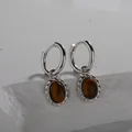 Detailed view of S925 sterling silver hoop earrings featuring natural oval tiger eye stones. - Natural Tiger Eye Earrings / Silver