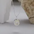 Makro-Detail einer S925 Silberkette mit einem eleganten ovalen weißen Muschel-Anhänger. - Natürlicher Weiße Muschel Halskette