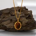 Close-up of a vintage oval tiger's eye stone pendant necklace with a golden scalloped frame - Natural Tiger Eye Necklace / Gold