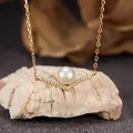 Detailed view of a gold-plated silver V-shaped pendant with a freshwater pearl and stones. - Necklace / Natural Freshwater Pearl Necklace Gold