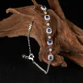 Detailed view of S925 sterling silver bracelet with blue gemstones resting on rustic wood - Bezel Design / Sapphire Blue