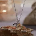 Macro-opname van een zilveren ketting met ovale citrien hanger en fonkelende strik. - Strik Ketting (R393) / 40+5cm Kettinglengte / Geel (Natuurlijke Citrien)