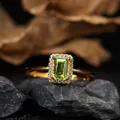Detailed macro shot of an emerald-cut peridot ring with a shimmering diamond halo - Natural Peridot Ring / Gold