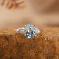Vista macro di un elegante anello in argento sterling 925 con topazio azzurro ovale - Aperto Regolabile / Topazio Naturale (Blu Chiaro)