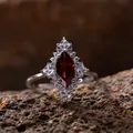 Primer plano de un anillo de plata S925 con granate rojo marquesa y topacio blanco - Anillo de Granate / Burdeos