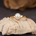 Macro detail of a V-shaped golden sterling silver ring with a lustrous freshwater pearl. - Natural Freshwater Pearl Ring Gold