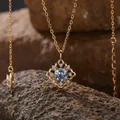 Detaillierter Nahaufnahme eines Blautopas-Anhängers in einem goldenen Blumenrahmen - Natürlicher Topas Halskette / Gold