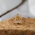 Detaillierte Nahaufnahme eines Goldrings mit gelbem Edelstein und Halo-Pavé-Diamantfassung - Natürlicher Citrin Ring / Gold