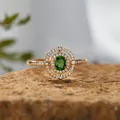 Nahaufnahme eines Goldrings mit grünem Diopsid-Edelstein und Doppel-Halo auf Stein - Natürlicher Diopsid Ring / Gold