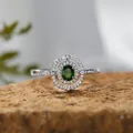 Nahaufnahme eines S925-Silberrings mit grünem Diopsid-Edelstein und funkelndem Halo. - Natürlicher Diopsid Ring / Silber