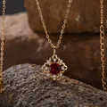Nahaufnahme einer S925 Sterlingsilberkette mit einem Granatanhänger auf Natursteinen - Natürlicher Granat Halskette / Gold