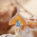 Dettaglio del pendente a coda di balena con topazio blu e pietre incastonate - Collana Topazio Naturale