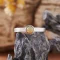Dettaglio di un anello in argento S925 con texture a corteccia e pietra opale rotonda - Opale Naturale / Argento
