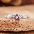 Macro detail view of a natural round faceted purple amethyst gemstone set in a textured silver ring - Natural Amethyst Ring