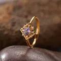 Detailansicht eines vintage vergoldeten Amethystrings auf einem strukturierten Stein - Natürlicher Amethyst Ring / Gold