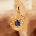 Close-up of a gold-plated silver pendant with a central oval blue tanzanite gemstone - Natural Sapphire (Gold)