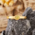 Macro dettaglio di un anello con opale e fascia dorata con texture a corteccia - Opale Naturale / Oro