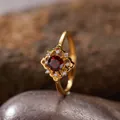Nahaufnahme eines goldenen Vintage-Rings mit rotem Granatstein und verzierten Details - Natürlicher Granat Ring / Gold