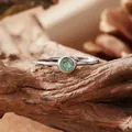 Detail shot of a minimalist S925 silver ring with a brilliant round green gemstone. - Open Ring / Natural Emerald