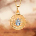 Close-up of golden sunburst pendant with light blue oval gemstone and zircon detail - Natural Topaz (Gold)