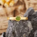 Close-up of S925 silver ring with round green jasper stone and golden textured band - Natural Jasper / Gold
