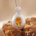Macro view of teardrop brushed silver pendant featuring a faceted oval citrine gemstone - Natural Yellow Quartz Ring Silver