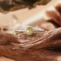 Detail view of a round yellow citrine gemstone set in a minimalist S925 silver ring - Open Ring / Natural Peridot